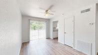 Located at 9402 Gnarled Chestnut Ct in Houston, TX, this single-story, 3-bedroom, 3-bathroom home offers a clean, functional layout with a warm and inviting atmosphere throughout. Light-toned wood-look flooring runs consistently across the living spaces, complementing the crisp white walls and creating a cohesive, modern feel.

The combined living and dining area serves as the heart of the home, featuring a ceiling fan, a textured ceiling, and a sliding glass door framed by vertical blinds that floods the room with natural light and provides views of the surrounding greenery. The galley-style kitchen is efficiently designed with white shaker cabinetry, stone-look countertops, a double-basin sink, and black appliances including a refrigerator and range.

Each of the three bedrooms offers wood-look flooring, ceiling fans, and natural light through windows with outdoor views. Several bedrooms include closets, providing practical storage. The primary bedroom features a sliding glass door with outdoor access. The three bathrooms are cleanly appointed, with at least one featuring a full tub-shower combo with brushed gold fixtures and white cabinetry with ample storage. A connecting hallway links the private quarters seamlessly to the main living areas.