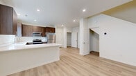 Located on N Boxwood St in Camas, WA, this contemporary two-story home offers 3 bedrooms, 3 bathrooms, and a thoughtfully designed layout spread across two floors. The main level is anchored by an open-concept kitchen and living area finished with light hardwood-style flooring that creates a bright, cohesive feel. The kitchen is well-appointed with rich dark wood cabinetry, white quartz countertops, a central island, and a full suite of stainless steel appliances including a refrigerator, range, microwave, and dishwasher. Natural light filters in through multiple windows with blinds. The living room features a striking floor-to-ceiling tile-surround linear fireplace that serves as a bold focal point. A pantry closet and dedicated laundry area add practical convenience on the main floor. The upper level houses the bedrooms, including a primary suite with a walk-in closet outfitted with wire shelving. All bedrooms feature plush carpeting and clean white walls. The three bathrooms maintain a consistent modern aesthetic, with wood-toned vanities, white countertops, and hardwood-style flooring. One bathroom includes a full soaking tub. Panel-style interior doors and recessed lighting throughout complete the home's clean, contemporary design.