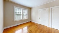 Located at 724 29th St S in Birmingham, Alabama, this one-bedroom, one-bathroom home offers a well-organized single-floor layout with a collection of classic architectural details throughout. Warm hardwood floors run through the living room, hallways, and bedroom, lending a timeless character to the interior. The living room is highlighted by a distinctive arched alcove and crown molding, adding depth and charm to the space. Natural light filters in through multiple double-hung windows dressed with blinds, offering views of the surrounding greenery. The bedroom is a comfortable, sunlit room featuring multiple windows on two walls, a ceiling fan, and a closet, providing both airflow and ample storage. A second connected room with hardwood floors and large windows adds flexibility to the layout. The kitchen features a classic black-and-white checkered tile floor, white upper cabinetry, a double-basin stainless steel sink, a gas range, and a full-size refrigerator, with a window providing natural light. The bathroom is outfitted with traditional penny tile flooring, a pedestal sink, a tub-shower combination with white subway tile surround, and a mirrored medicine cabinet, completing this well-appointed home.