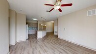 Located at 150 Bear Springs Drive in Winter Springs, FL, this well-appointed three-bedroom, two-bathroom residence offers a thoughtfully designed single-floor layout. The open-concept main living area seamlessly integrates the living room, dining space, and kitchen, creating a bright and cohesive gathering space. Wood-look flooring flows throughout, complemented by neutral warm-toned walls and ceiling fans in the main living and bedroom areas.

The kitchen is a standout feature, anchored by a large granite-topped island with an undermount sink and pendant lighting above. Contemporary wood-grain cabinetry, a tiled backsplash, stainless steel refrigerator, and black appliances complete the space. A pantry provides additional storage convenience.

The primary bedroom is generously sized and includes access to a well-finished bathroom featuring granite countertops, a wood-toned vanity, a tiled tub/shower combination, and wood-look tile flooring. Additional bedrooms are comfortably scaled, each with ceiling fans and natural light from large windows.

A dedicated laundry room, multiple closets including a walk-in with wire shelving, and a private balcony with outdoor views add to the home's functionality. The overall ambiance is clean, modern, and move-in ready.