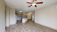Located at 150 Bear Springs Drive in Winter Springs, FL, this well-appointed three-bedroom, two-bathroom residence offers a thoughtfully designed single-floor layout. The open-concept main living area seamlessly integrates the living room, dining space, and kitchen, creating a bright and cohesive gathering space. Wood-look flooring flows throughout, complemented by neutral warm-toned walls and ceiling fans in the main living and bedroom areas.

The kitchen is a standout feature, anchored by a large granite-topped island with an undermount sink and pendant lighting above. Contemporary wood-grain cabinetry, a tiled backsplash, stainless steel refrigerator, and black appliances complete the space. A pantry provides additional storage convenience.

The primary bedroom is generously sized and includes access to a well-finished bathroom featuring granite countertops, a wood-toned vanity, a tiled tub/shower combination, and wood-look tile flooring. Additional bedrooms are comfortably scaled, each with ceiling fans and natural light from large windows.

A dedicated laundry room, multiple closets including a walk-in with wire shelving, and a private balcony with outdoor views add to the home's functionality. The overall ambiance is clean, modern, and move-in ready.