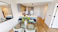 Located at The Press in the heart of Wilmington, Delaware, this thoughtfully designed one-bedroom, two-bathroom residence offers a refined modern living experience across a single, efficient floor. The open-concept kitchen and living area serves as the centerpiece of the home, featuring sleek gray flat-front cabinetry, stainless steel appliances, a white quartz peninsula with bar seating, and a linear pendant light — all anchored by warm-toned hardwood flooring. The living area is bathed in natural light through dramatic floor-to-ceiling windows that frame direct views of the outdoor pool and courtyard below, creating a seamless indoor-outdoor connection. The bedroom is a serene retreat, benefiting from the same expansive window design and pool views, offering generous proportions and direct access to a walk-through closet with custom built-in shelving. The primary bathroom is finished with large-format marble-look wall tiles in a glass-enclosed shower, complemented by clean white countertops and tile flooring. A second full bathroom provides added convenience. Throughout the residence, crisp white walls, recessed lighting, and contemporary finishes contribute to a clean, minimalist aesthetic suited for modern urban living.