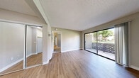 Located at 760 South Hill Road in Ventura, California, this single-floor, one-bedroom unit offers a well-organized and functional layout. The living area greets you with wood-look laminate flooring and neutral, warm-toned walls that create a clean and welcoming ambiance. A full-length sliding glass door opens directly to a private outdoor patio enclosed by a lattice-style railing, allowing natural light to fill the space and offering a pleasant connection to the outdoors.

The bedroom features plush wall-to-wall carpeting in a neutral beige tone, soft gray walls, and a window overlooking greenery, providing natural light and a calm atmosphere. White panel doors and crisp white baseboards throughout add a polished, cohesive finish to each room.

A secondary area with wood-look flooring includes a mirrored sliding closet, providing ample storage, along with access to an additional room — likely a bathroom — and a built-in ventilation unit. The textured ceilings are consistent throughout the unit, adding a subtle traditional touch. The overall design is practical and clean, with a neutral color palette that makes the space feel bright, versatile, and easy to personalize. Situated in Ventura's 93003 zip code, the unit benefits from the area's mild Southern California climate.