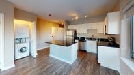 Located in Chicago's prestigious Gold Coast neighborhood, this single-floor unit at 66 W Oak St offers a well-designed layout with a cohesive, contemporary aesthetic throughout. Dark hardwood flooring extends across the main living areas, providing a rich contrast against the neutral-toned walls and white trim.

The kitchen is a standout feature, equipped with a full suite of stainless steel appliances including a refrigerator, range, microwave, and dishwasher. White cabinetry reaches toward the ceiling, offering ample storage, while dark granite countertops add a polished finish. A peninsula with matching granite serves as both a prep space and casual dining area. Track lighting illuminates the kitchen, and a window brings in natural light with views of the surrounding cityscape.

The living area is open and airy, benefiting from large sliding windows that frame elevated views of Chicago's urban landscape, including neighboring buildings and winter streetscapes. A louvered closet panel provides organized storage nearby.

The bathroom is cleanly appointed with a tub-shower combination featuring tiled surrounds, a white vanity with dark granite countertop, an undermount sink, and a well-lit mirror. The overall ambiance of the unit is modern and functional, well-suited for urban living.