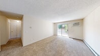 Located at 1860 52nd St E in Inver Grove Heights, MN, this one-bedroom, one-bathroom unit offers a well-organized and efficient layout across a single floor. The living area is finished with neutral-toned carpet and painted in light, warm hues, creating a clean and inviting atmosphere. A sliding glass door floods the space with natural light and opens to a private balcony with outdoor views, adding a pleasant sense of openness to the room. Textured ceilings are featured throughout the unit.

The galley-style kitchen is efficiently designed with white cabinetry accented by warm wood trim, white appliances including a range, microwave, and refrigerator, and a double sink. Tile flooring and ample cabinet storage make the kitchen both practical and easy to maintain.

The bedroom is a comfortable, well-proportioned retreat featuring plush carpeting, a ceiling fan with a light fixture, a window overlooking lush greenery, and a closet with classic six-panel doors. The bathroom includes a full tub-and-shower combination with clean white surround panels, offering a simple and functional design. Overall, the unit presents a tidy, move-in-ready space suited for comfortable everyday living.