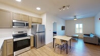 Located at 418 Harrison St in West Lafayette, Indiana, this 2-bedroom, 1-bathroom unit offers a practical and modern layout across a single floor. The open-concept living area seamlessly combines the kitchen, dining, and living spaces, creating an efficient and functional common area. The kitchen is equipped with stainless steel appliances, including a refrigerator, electric range, and microwave, complemented by light wood cabinetry and recessed lighting overhead. A dining table sits just steps from the kitchen, while the living area features a wall-mounted flat-screen TV, a ceiling fan, and a window that brings in natural light.

Both bedrooms are bright and simply designed, each featuring hardwood-style flooring, a ceiling fan, and a window with exterior views. The primary bedroom comfortably accommodates a bed and a dedicated study desk. The shared bathroom is clean and well-appointed, featuring a wood-toned vanity, a walk-in shower, and hardwood-style flooring. A second full bathroom is also present and similarly finished. The unit also includes the convenience of in-unit laundry and two closets for added storage. Crisp white walls and consistent flooring throughout give the space a cohesive, contemporary feel.