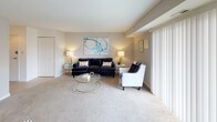 This single-floor residence offers a thoughtfully designed layout that balances comfort and functionality. The living room serves as the heart of the home, featuring plush carpeting, neutral walls, and large sliding glass doors fitted with vertical blinds that flood the space with natural light and provide views of the outdoors. The open flow connects seamlessly to a dedicated dining area, which features a pendant light fixture overhead and neutral carpeted flooring.

The kitchen is outfitted with rich dark-wood cabinetry, dark stone-look countertops, a gas range, dishwasher, and a double sink, all complemented by light tile flooring that adds a clean, practical finish.

The primary bedroom is generously proportioned, offering plush carpeting, multiple windows dressed with teal drapes, and ample room for a full furniture arrangement. The secondary bedroom, also carpeted, provides a comfortable and versatile space with a window for natural light.

Two bathrooms serve the residence, each featuring light tile floors, dark wood vanities, and clean white fixtures. One bathroom includes a shower with a decorative curtain, while the other presents a half-bath configuration. Together, the rooms create a cohesive, welcoming atmosphere throughout.