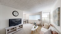 This 1-bedroom, 1-bathroom unit in Southfield, Michigan offers a thoughtfully laid-out floor plan that makes efficient use of its space. The living room serves as the heart of the home, featuring neutral-toned carpet, crisp white walls, and a textured ceiling that adds visual interest. A large window fitted with vertical blinds allows natural light to fill the room, creating a warm and inviting atmosphere suitable for both relaxing and casual dining. The galley-style kitchen is well-equipped with warm oak cabinetry, light marble-patterned countertops, a double sink, and black appliances including a refrigerator, electric range, and dishwasher. Dark hardwood-style flooring grounds the kitchen and extends into the bathroom, providing a clean contrast to the lighter living areas. The bedroom is a comfortable retreat featuring soft carpeting, a large window with natural views, a closet, and a textured ceiling consistent with the rest of the unit. The full bathroom is neatly finished with an oak vanity, white countertop, tiled shower-tub combo, and hardwood-style flooring. Throughout the unit, a consistent neutral color palette and clean finishes contribute to a cohesive and functional living environment.