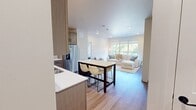 This contemporary apartment in Fargo, North Dakota, offers a well-designed living space of 870 square feet. The layout features two bedrooms, including a primary bedroom of 170 square feet, and two bathrooms. The heart of the home is an open-concept living area that combines the kitchen and living room, creating a spacious and inviting atmosphere.

The kitchen is a highlight, boasting modern cabinetry in neutral tones, stainless steel appliances, and a stylish backsplash. A central island with seating serves as both a dining area and additional workspace. The living room is bathed in natural light from large windows, which also provide views of the surrounding area.

Both bedrooms are well-proportioned, with the primary bedroom offering ample space. The bathrooms feature clean lines and modern fixtures, with one showcasing a spacious vanity and storage cabinet. Throughout the apartment, you'll find a cohesive design aesthetic with neutral wall colors, hardwood-style flooring in the main living areas, and plush carpeting in the bedrooms.

The apartment's design maximizes space efficiency while maintaining a sense of openness. Large windows in every room, including a picture window in the living area, flood the space with natural light and offer views of the cityscape. Thoughtful touches like recessed lighting, roller shades, and contemporary artwork contribute to the overall modern and comfortable ambiance of this urban dwelling.