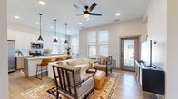 This single-story home at 775 N Ten Mile Rd in Meridian, Idaho offers a thoughtfully designed open-concept floor plan with a cohesive, contemporary aesthetic throughout. The main living area seamlessly connects the living room, dining space, and kitchen, creating a welcoming, communal atmosphere. Light wood-look flooring, recessed lighting, and a ceiling fan contribute to the bright, airy feel of the space, while large windows fitted with blinds allow ample natural light to flow in. A glass-paneled exterior door provides direct outdoor access from the living area.

The kitchen features two-tone cabinetry — white upper cabinets paired with natural wood-toned lower cabinets — complemented by white quartz countertops, a subway tile backsplash, and stainless steel appliances. A walk-in pantry with built-in shelving adds generous storage. Pendant lights illuminate the kitchen bar seating area.

The bathroom includes a single vanity with wood-toned cabinetry, white quartz countertops, black hardware accents, and a tiled walk-in shower. Bedrooms are comfortably sized with tall windows and neutral carpeting. A dedicated laundry room houses a full-size top-load washer and dryer, adding everyday convenience to this well-appointed home.