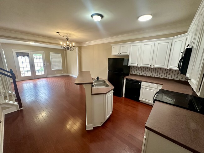 Kitchen opens to dining area and bonus space that leads to the back patio and parking area - 8608 Gauphin Pl