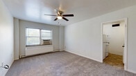 Located at 905 Jefferson St in Kansas City, MO, this one-bedroom, one-bathroom unit offers a practical and comfortable layout across a single floor. The living room is a welcoming space featuring neutral carpet, soft gray walls, a ceiling fan with light fixture, and a window fitted with a wall-mounted air conditioning unit and baseboard radiator, ensuring year-round comfort. Natural light flows in through the window, creating a bright and airy atmosphere.

The bedroom is a well-proportioned room also finished with plush carpet, a ceiling fan, and a window with blinds overlooking the outdoors. It provides access to two closets, offering ample storage—one of which is a walk-in style closet.

The galley-style kitchen is efficiently designed with white cabinetry, dark countertops, a full-size refrigerator, a gas range, and a single-basin sink. Tile flooring adds a clean, practical touch to this functional cooking space.

The bathroom features a classic design with blue mosaic tile flooring, a white soaking tub with shower, a wall-mounted sink, and a window that allows for natural ventilation and light. A hallway connects the rooms, contributing to a smooth and logical flow throughout the unit.