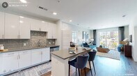 Located in Morrisville, NC, this thoughtfully designed 2-bedroom, 2-bathroom residence offers a comfortable and modern living experience across a single floor. The open-concept layout seamlessly connects the kitchen and living room, creating a bright and welcoming communal space. The kitchen is outfitted with white shaker cabinetry, a gray tile backsplash, stainless steel appliances, and a central island with bar seating — ideal for casual dining and entertaining. Wood-style flooring runs throughout, adding warmth and continuity to the space. The living room is generously sized, filled with natural light, and opens directly onto a private balcony through sliding glass doors, offering pleasant outdoor views. The primary bedroom features large windows that bring in ample natural light and is complemented by a dedicated closet. The second bedroom includes a bold accent wall and its own closet, providing a distinct and inviting atmosphere. Both bathrooms are finished with wood-style flooring, white vanity cabinetry, and quartz-style countertops; one bathroom includes a tiled tub-shower combination, while the other offers a walk-in shower. Two closets provide practical storage throughout the residence, rounding out this well-balanced and functional home.