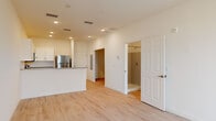 Located at 1401 Davenport Blvd in Davenport, Florida, this 2-bedroom, 1-bathroom unit offers a clean, modern layout designed for efficient and comfortable living. Light wood-look flooring runs throughout the entire space, creating a bright and cohesive aesthetic complemented by crisp white walls and recessed lighting.

The open-concept kitchen and living area serves as the heart of the unit. The kitchen is well-appointed with white shaker-style cabinetry, granite countertops, a peninsula with additional prep and storage space, and a full suite of stainless steel appliances including a refrigerator, range, over-the-range microwave, and dishwasher. The adjoining living area benefits from natural light through a window overlooking the exterior.

Both bedrooms are comfortably sized, featuring the same light flooring and neutral walls, with ample room for standard furnishings. The primary bedroom offers a dedicated closet with a hanging rod for organized storage. The bathroom is neatly finished with a granite-topped vanity, a framed mirror, and a tiled walk-in shower stall. The overall ambiance of the unit is clean and contemporary, making it a functional and inviting living space.