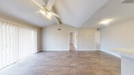 Located at 6425 Bankside Dr in Houston, TX, this single-story, one-bedroom, one-bathroom unit offers a well-designed layout that maximizes functionality and comfort. The living room is an immediate standout, featuring dramatic vaulted ceilings with exposed beams and a ceiling fan, creating an airy and open atmosphere. Rich wood-style flooring runs throughout the main living areas, while a large sliding glass door fitted with vertical blinds fills the space with natural light. The living area connects seamlessly to the rest of the unit through an open hallway. The galley-style kitchen is thoughtfully outfitted with white shaker cabinetry, light quartz countertops, a stainless steel sink, and stainless steel appliances including a range and refrigerator, all set over wood-style flooring. The bedroom offers a comfortable and quiet retreat, featuring plush carpeting, a ceiling fan with light fixture, and a window that allows in natural light. A dedicated closet provides convenient storage. The bathroom is clean and practical, featuring a tub-shower combination with tiled surround, a white vanity with storage, and wood-style flooring. A dedicated entrance completes this well-appointed Houston residence.