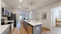 Located in Brentwood, TN, this well-appointed single-floor residence offers a smart, functional layout across a comfortable footprint. The open-concept kitchen and living area serves as the heart of the home, anchored by a central island with a white quartz countertop, undermount sink, and pendant lighting overhead. Gray shaker-style cabinetry, a subway tile backsplash, and stainless steel appliances — including a French door refrigerator, range, microwave, and dishwasher — complete the kitchen. Light hardwood flooring flows seamlessly into the living area, where natural light filters through exterior-facing doors and windows, creating a bright, welcoming atmosphere. The living room offers generous space for seating and relaxation. The bedroom features a large window that fills the room with natural light, complemented by neutral tones and plush carpeting. The bathroom is finished with gray cabinetry, white countertops, and tile flooring, with direct access to a spacious walk-in closet equipped with wire shelving systems. A versatile office with hardwood floors and a bright window provides an ideal dedicated workspace. Recessed lighting throughout adds a clean, modern touch to the overall ambiance of this refined residence.