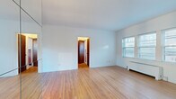Located at 2936 Dean Pkwy in Minneapolis, MN, this single-floor unit offers a practical and efficiently arranged layout comprising a living room, kitchen, and bathroom. The living room is finished with warm hardwood flooring that extends throughout the main areas, complemented by crisp white walls that create a clean, bright atmosphere. Multiple windows fitted with blinds allow natural light to fill the space, while a classic radiator provides in-unit heating. The kitchen features white cabinetry with ample storage, a stainless steel sink, and neutral countertops, all set atop tile flooring. A window above the sink brings in additional natural light. The bathroom is a standout with its retro aesthetic, showcasing full pink wall tiling accented by bold navy blue border tiles and fixtures, along with a full-size soaking tub. The overall design reflects a classic mid-century character with well-preserved original details. The unit's compact footprint makes for easy maintenance while still providing all essential living spaces in a functional and cohesive arrangement.