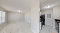Located at 511 E Hackberry St in Rockport, Texas, this single-floor unit offers a straightforward and functional layout finished with light-toned tile flooring throughout. The open living area greets you at the entrance, featuring large windows that allow ample natural light to fill the space, creating a bright and airy atmosphere. The neutral, light gray walls and clean white trim contribute to a cohesive, modern aesthetic throughout.

The galley-style kitchen is efficiently designed with white cabinetry, dark granite-style countertops, and black appliances including a refrigerator, range, and dishwasher. An electrical panel is conveniently accessible within the kitchen corridor, and the layout maximizes use of the available space.

The bedrooms are well-proportioned, each featuring ceiling fans with integrated lighting and windows with blinds that offer views of surrounding greenery. The natural light and ceiling fans contribute to a comfortable, practical living environment.

The bathroom is neatly appointed with a white vanity, dark countertop, mirrored medicine cabinet, and a tub-shower combination. The tile flooring continues here, maintaining a consistent design language across the unit.

Overall, this Rockport unit presents a clean, low-maintenance living space well-suited for those seeking practical coastal Texas living.