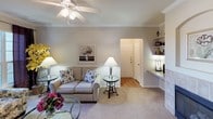 This single-floor residence offers a thoughtfully designed layout with a comfortable flow between its main living areas. The living room serves as the heart of the home, featuring neutral-toned carpet, crown molding, a ceiling fan, and built-in shelving along one wall. A dedicated workspace nook adds practical functionality to the space.

The dining area is bright and welcoming, benefiting from multiple windows that allow natural light to pour in. Crown molding continues throughout, adding a refined touch, while a pendant light fixture anchors the space above the dining table.

The kitchen is equipped with white cabinetry, ample counter space, and appliances including a range and over-the-range microwave, offering an efficient and clean cooking environment.

Both bedrooms are carpeted and comfortably sized, each receiving natural light through well-positioned windows. One bedroom includes access to a spacious walk-in closet outfitted with wire shelving and hanging rods on multiple walls, providing generous storage.

Two full bathrooms serve the residence, each featuring a soaking tub and shower combination, tile flooring, and vanity with storage. The overall aesthetic throughout is clean, neutral, and move-in ready.