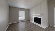 Located at 500 E Loop 820 in Fort Worth, TX, this 2-bedroom, 2-bathroom residence offers a well-organized single-floor layout designed for comfortable everyday living. The entryway opens through a hallway into the main living areas, where wood-look flooring in a warm gray tone flows consistently throughout the home. The living room serves as a central gathering space, highlighted by a white shiplap-accented fireplace wall that adds a charming focal point, complemented by a window that brings in natural light and outdoor views. The kitchen features white cabinetry with contemporary hardware, light quartz-style countertops, a classic subway tile backsplash, and black appliances including a refrigerator and range. Both bedrooms offer a calm, neutral palette with gray walls, wood-look flooring, and windows fitted with blinds that provide natural light and exterior views. The primary bedroom includes two closets, offering ample storage. Each bathroom is outfitted with a full tub-shower combination and built-in shelving for added convenience. Textured ceilings are present throughout the home. The layout connects efficiently through a central hallway, making the space feel organized and cohesive from entry to the private bedroom areas.