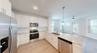 Located at 3240 Champion Ring Rd. in Fort Myers, FL, this thoughtfully designed one-bedroom, one-bathroom residence offers a clean, modern aesthetic throughout its efficiently arranged single-floor layout. The open-concept living area seamlessly connects the kitchen, dining, and living spaces, creating a bright and airy atmosphere enhanced by multiple windows and light wood-tone flooring throughout.

The kitchen is a standout feature, outfitted with crisp white shaker cabinetry, speckled granite countertops, a peninsula with an undermount sink and pendant lighting, and a full suite of stainless steel appliances including a refrigerator with ice maker, electric range, over-the-range microwave, and dishwasher. The living area is bathed in natural light from multiple windows and features a ceiling fan, with direct access to a private patio.

The bedroom is a comfortable and well-lit retreat with a ceiling fan, a large window with exterior views, and access to generous closet space — four closets in total provide exceptional storage throughout the unit. The bathroom features a glass-enclosed walk-in shower with white tile surround and brushed nickel fixtures, complemented by wood-look flooring. The overall palette of white walls, light flooring, and modern finishes lends a fresh, contemporary feel to this Fort Myers residence.