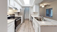 Located at 700 Martins Creek Blvd in Summerville, South Carolina, this single-floor residence offers a thoughtfully designed layout with a clean, neutral palette throughout. The spacious living area is highlighted by plush carpeting, a ceiling fan, and a wood-surround fireplace that serves as a natural focal point. Sliding glass doors flood the room with natural light and open directly to a private patio with outdoor views, creating a seamless indoor-outdoor connection. The galley-style kitchen is well-appointed with white cabinetry, light granite-style countertops, a stainless steel sink, and stainless appliances including a range and refrigerator. A skylight above brightens the space, while wood-look luxury vinyl flooring adds warmth. A pass-through counter connects the kitchen to the living area, enhancing the open feel. The bathrooms feature white vanity cabinetry with granite-style countertops, wood-look flooring, and brushed nickel fixtures, with one bath offering a full tub and shower combination. Bedrooms are generously sized with soft carpeting and windows providing natural light. A dedicated laundry area with in-unit washer and built-in shelving adds everyday convenience. The overall ambiance is bright, clean, and move-in ready.