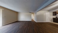 Located at 2220 Prairie St in Emporia, Kansas, this single-story home offers three bedrooms and four bathrooms within a well-organized floor plan. The open-concept living and dining area makes a strong first impression with rich, dark hardwood flooring, neutral-toned walls, and a textured ceiling. Large sliding glass doors fitted with vertical blinds allow natural light to fill the space and provide outdoor access.

The kitchen connects to the living area via a pass-through window with a breakfast bar countertop, creating an interactive layout ideal for entertaining. Dark wood cabinetry pairs with granite-look countertops and a full suite of stainless steel appliances, including a range, over-the-range microwave, dishwasher, and refrigerator. Light tile flooring completes the kitchen's clean, functional aesthetic.

The generously sized primary bedroom offers ample square footage, while the additional bedrooms feature soft carpet, neutral walls, and large windows for natural light. All four bathrooms are finished with light tile flooring and textured walls, maintaining a consistent, clean design throughout. A hallway and closet provide additional storage and connectivity across the home. Ceiling fans are present throughout, contributing to the home's practical and comfortable character.