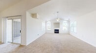 Located at 5548 Magnolia Run Cir in Virginia Beach, VA, this single-floor, 3-bedroom, 3-bathroom home offers a well-organized layout with a thoughtful blend of comfort and functionality. The centerpiece of the home is the spacious living and dining area, which features striking vaulted ceilings accented by a ceiling fan and flanked by two arched windows that fill the room with natural light. A built-in fireplace with a display niche above anchors the main wall, creating a warm and inviting focal point. Neutral carpet throughout the living spaces adds a soft, cohesive feel.

The kitchen is equipped with light wood cabinetry, a peninsula with countertop seating, wood-look flooring, and black appliances, offering a practical and functional workspace. The primary bedroom is generously sized and includes a walk-in closet with wire shelving and a sliding glass door that opens to a private balcony with outdoor views. The additional bedrooms are carpeted and feature windows with blinds, providing natural light and privacy. The bathrooms are clean and functional, with at least one featuring a tub-shower combination and wood-look flooring. A hallway connects the rooms, contributing to the home's efficient and accessible single-floor flow.