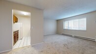Located at 120 Meyer Rd in Buffalo, NY, this single-floor unit offers a practical and well-organized layout with three bedrooms and two bathrooms. The living area features neutral-toned carpet flooring and a textured ceiling, with a large window that allows natural light to fill the space. A baseboard heating system and wall-mounted air conditioning unit provide year-round climate control. The kitchen is outfitted with white tile flooring, warm wood cabinetry, granite-look countertops, a stainless steel sink, and includes a full-size refrigerator and dishwasher. The bedrooms are carpeted and finished with neutral walls, offering a quiet and comfortable atmosphere; the primary bedroom is generously sized relative to the overall footprint. The two bathrooms feature white tile flooring, with one bathroom equipped with a full tub-and-shower combination featuring a clean, all-white surround. A connecting hallway links the bedrooms and bathrooms, providing a functional flow throughout the unit. The overall aesthetic is clean and understated, with a consistent warm beige palette across all rooms, making the space a versatile and move-in-ready home in the Buffalo area.