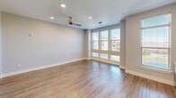 This contemporary 640 square foot apartment in Franklin, TN, offers a thoughtfully designed living space that maximizes efficiency and style. The open-concept layout seamlessly integrates the kitchen and living areas, creating a spacious feel despite the compact footprint. The kitchen boasts crisp white cabinetry extending to the ceiling, providing ample storage. Stainless steel appliances, including a refrigerator, stove, and microwave, complement the modern aesthetic. A subtle blue-gray backsplash adds a touch of color to the predominantly white palette.

The living area is bathed in natural light, thanks to large windows that offer views of the surrounding area. A modern ceiling fan enhances air circulation and adds a decorative touch. The warm wood-toned flooring unifies the space and contrasts beautifully with the light walls and cabinetry.

The bathroom, while not extensively shown, appears to maintain the apartment's clean, modern design with white fixtures and neutral tones. Additional features include recessed lighting throughout, providing even illumination, and what appears to be a separate area that could serve as a bedroom or home office.

Overall, this apartment offers a bright, airy living space with a contemporary design that emphasizes functionality and style, ideal for modern urban living.