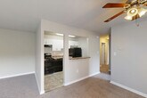 Located at 6443 Hil Mar Dr in District Heights, MD, this single-floor, three-bedroom, two-bathroom home offers a practical and comfortable layout. The living room is generously proportioned, featuring plush wall-to-wall carpeting, a ceiling fan, and large sliding glass doors dressed with vertical blinds that invite abundant natural light and provide access to an outdoor balcony area with greenery views. The kitchen is efficiently designed with white cabinetry, dark granite-style countertops, tile flooring, and black appliances including a refrigerator, dishwasher, and range. A pass-through counter connects the kitchen to the living area, creating an open and social atmosphere. A hallway links the common areas to the three bedrooms, each finished with soft carpeting and neutral tones. The primary bedroom is notably spacious, offering a window with outdoor views and ample room. Five closets throughout the home provide exceptional storage. The two bathrooms are finished with tile flooring; one features a tub/shower combo with a white vanity, while the second includes a soaking tub and toilet. The home's clean, neutral palette and functional layout make it a versatile and inviting space.