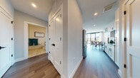 Located at 150 River St in Hackensack, NJ, this thoughtfully designed single-floor residence offers a seamless blend of modern aesthetics and functional living. Wide-plank hardwood flooring flows throughout the open layout, connecting each space with a cohesive, contemporary feel.

The galley-style kitchen is a standout feature, outfitted with crisp white shaker cabinetry, dark countertops, a decorative tile backsplash, and a full suite of stainless steel appliances including a gas range, built-in microwave, and French door refrigerator. Recessed lighting enhances the clean, professional finish.

The living area is bathed in natural light through expansive floor-to-ceiling windows that frame outdoor views of the surrounding Hackensack cityscape. The dining space sits adjacent to these windows, creating a bright and inviting setting for entertaining.

The bedrooms are generously proportioned, each offering a calm, neutral palette, with one bedroom featuring direct sightlines to the living area and access to natural light. The bathrooms are finished with light wood-tone tile flooring, white vanity cabinetry with dark hardware, glass-enclosed showers, and clean, modern fixtures throughout.

A well-placed hallway connects the living spaces to the private areas, providing a logical and comfortable flow throughout this polished Hackensack residence.