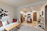 Located at 12121 Pacific Hwy in Everett, WA, this efficient one-bedroom, one-bathroom unit offers a thoughtfully organized single-floor layout that maximizes every square foot. The open-concept living and dining area flows seamlessly into the kitchen, creating a bright, cohesive space ideal for everyday living. Light wood-style flooring runs throughout the main area, complementing the clean, neutral color palette.

The kitchen is well-appointed with white shaker cabinetry offering generous storage, white countertops, and a full suite of stainless steel appliances including a refrigerator, dishwasher, electric range, and over-the-range microwave. Recessed lighting illuminates the space effectively, adding a modern touch.

The bedroom features plush carpet flooring and a sliding wood-panel closet, providing ample storage. A large sliding glass door fills the room with natural light and opens to an outdoor view of the surrounding courtyard and building exterior. The bathroom is finished with light wood-look tile flooring, a vanity with under-cabinet storage, and clean, minimalist fixtures. The warm wood-toned interior doors throughout the unit add a cohesive design element, tying together the modern and natural aesthetic of this compact, functional home.