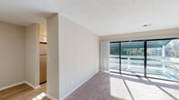 Located at 603 Plum Nearly Ln in Wilmington, NC, this single-floor residence offers a well-organized layout with a bright, open feel throughout. The living area features plush carpeting and is bathed in natural light streaming through large sliding glass doors that open to a private balcony overlooking lush greenery. The space flows seamlessly into an adjacent area with wood-style flooring, providing a functional transition between rooms.

The kitchen is thoughtfully appointed with white shaker-style cabinetry, marble-look countertops, a double stainless steel sink, and a full suite of stainless steel appliances including an electric range with overhead microwave and a dishwasher. A window above the sink allows for additional natural light.

The bedrooms are generously sized with soft carpeting, neutral wall tones, and windows fitted with blinds for light control and privacy. Each bedroom includes closet space, with at least one featuring a bifold-door closet with built-in shelving.

The bathroom is finished with wood-style vinyl flooring, a white vanity with ample cabinet storage, and a full tub-shower combination with clean white tile surround. Textured ceilings and crisp white trim are consistent throughout, contributing to a clean, cohesive aesthetic across the entire space.