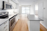 Located at 95 Davisville Ave in Toronto's Davisville Village neighbourhood, this seventh-floor unit offers a thoughtfully designed two-bedroom, one-bathroom layout making efficient use of its compact footprint. Light hardwood flooring runs throughout the main living areas, contributing to a bright, cohesive aesthetic.

The kitchen is a standout feature, equipped with a full suite of stainless steel appliances including a refrigerator, electric range, microwave, and dishwasher. White cabinetry extends to the ceiling, maximizing storage, while a peninsula with a neutral countertop provides additional prep space and casual seating potential. The kitchen flows naturally into the living area, which benefits from a large sliding window that draws in natural light and provides access to the balcony, offering views of the surrounding neighbourhood.

The primary bedroom is a well-proportioned space featuring a window with a roller blind, light-toned walls, and continued hardwood flooring. The second bedroom mirrors this clean, understated design. The bathroom features tile flooring, an undermount sink set in a grey-toned vanity, a large mirror with overhead lighting, and a clean, neutral finish throughout.