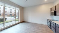 Located at 2939 Smallman St, Unit 213, in Pittsburgh's vibrant Strip District, this 470-square-foot, one-bedroom apartment offers a thoughtfully designed single-floor layout. The open-concept living and kitchen area features light wood-tone flooring, recessed lighting, and an exposed metallic ductwork detail that adds an industrial character to the space. The kitchen is equipped with dark espresso cabinetry, a white subway tile backsplash, stainless steel appliances including a refrigerator, electric range, and built-in microwave, along with a single-basin sink. A large sliding glass door in the living area floods the space with natural light and provides views of an outdoor amenity area with a pool. The 100-square-foot bedroom is carpeted and includes access to a dedicated closet, offering practical storage. A hallway connects the main living areas to the bedroom and bathroom. Neutral tones throughout the unit create a clean, modern ambiance. This compact yet functional apartment is well-suited for those seeking contemporary urban living in one of Pittsburgh's most dynamic neighborhoods.