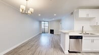 Located in the desirable West Los Angeles neighborhood of 90025, this one-bedroom, two-bathroom residence offers a well-designed layout with clean, contemporary finishes throughout. Light-toned luxury vinyl plank flooring runs continuously through every room, creating a cohesive and modern aesthetic.

The open-concept living area is a standout feature, anchored by a fireplace and sliding glass doors that lead to an outdoor balcony, filling the space with natural light. Crown molding and recessed lighting add refined detail to the living room ceiling, while a stylish chandelier provides an elegant focal point.

The kitchen is efficiently designed with crisp white shaker cabinetry, a peninsula with a built-in sink and dishwasher, stainless steel appliances including a gas range, microwave, and refrigerator, and a skylight that brings in additional natural light.

The bedroom is a comfortable, well-proportioned retreat featuring a large window with outdoor views, recessed lighting, and access to a dedicated closet. The two bathrooms are finished in a clean, neutral palette — one featuring a double-sink vanity with gray cabinetry and a framed mirror, and the other including a full soaking tub with an overhead shower and brushed nickel fixtures. The overall ambiance is bright, clean, and move-in ready.