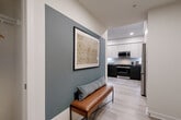 Located at 3461 La Cadena Dr in Riverside, CA, this well-appointed one-bedroom, one-bathroom residence offers a thoughtfully designed single-floor layout with modern finishes throughout. The welcoming entryway features a striking slate-blue accent wall, light wood-style flooring, and a hallway that leads seamlessly into the main living areas. The contemporary kitchen is a standout, equipped with two-tone cabinetry — crisp white upper cabinets and dark lower cabinets — stainless steel appliances, a tile backsplash, and a central island with bar seating, ideal for casual dining. The living room continues the modern aesthetic with a bold teal accent wall, large windows that invite natural light, and direct access to a private patio. The outdoor patio offers a comfortable seating area with views of the surrounding building courtyard. The bedroom provides a cozy retreat with carpeted flooring, a large window with natural light, and convenient access to two closets. The bathroom features a tub-shower combination with clean white tile surround and a coordinating teal lower wall detail. Additional functional spaces include a dedicated laundry area and an attached private garage with an automatic opener.