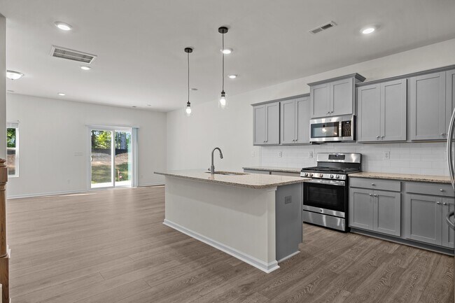 Spacious kitchen with modern appliances, a large island, and LVP flooring - 2863 Aubrey St