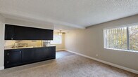 Located at 7190 Calvine Rd in Sacramento, CA, this 2-bedroom, 3-bathroom single-floor residence offers a practical and well-appointed layout. The open-concept kitchen and living area serves as the heart of the home, featuring dark espresso cabinetry, granite-style countertops, stainless steel appliances including a refrigerator, dishwasher, and range, and light hardwood-style flooring. A breakfast bar peninsula connects the kitchen to the living area, which is outfitted with a ceiling fan and windows that bring in natural light and views of surrounding greenery. The bedrooms are carpeted and neutrally toned, with the spacious primary bedroom offering a generous footprint and access to its own bathroom. Additional bedrooms are well-sized with large windows and textured ceilings. The three bathrooms are consistently finished with dark vanity cabinetry, granite-style countertops, mirrored medicine cabinets, and light wood-style flooring. Shower and tub enclosures feature sliding glass doors. A hallway and three closets provide ample storage throughout. The overall aesthetic is clean and functional, with a neutral warm palette carried consistently across all rooms.