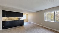 Located at 7190 Calvine Rd in Sacramento, CA, this 2-bedroom, 3-bathroom single-floor residence offers a practical and well-appointed layout. The open-concept kitchen and living area serves as the heart of the home, featuring dark espresso cabinetry, granite-style countertops, stainless steel appliances including a refrigerator, dishwasher, and range, and light hardwood-style flooring. A breakfast bar peninsula connects the kitchen to the living area, which is outfitted with a ceiling fan and windows that bring in natural light and views of surrounding greenery. The bedrooms are carpeted and neutrally toned, with the spacious primary bedroom offering a generous footprint and access to its own bathroom. Additional bedrooms are well-sized with large windows and textured ceilings. The three bathrooms are consistently finished with dark vanity cabinetry, granite-style countertops, mirrored medicine cabinets, and light wood-style flooring. Shower and tub enclosures feature sliding glass doors. A hallway and three closets provide ample storage throughout. The overall aesthetic is clean and functional, with a neutral warm palette carried consistently across all rooms.