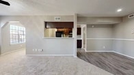 Located at 5918 Baymeadows Ln in Arlington, Texas, this 2-bedroom, 2-bathroom single-floor residence offers a practical and well-appointed layout. The open-concept living room is finished with plush carpet and neutral-toned walls, creating a warm and versatile space. A textured ceiling and built-in ventilation add functional detail throughout. The kitchen connects to the living area via a pass-through counter, and features rich dark wood cabinetry, light quartz-style countertops, wood-look vinyl flooring, and black stainless appliances including an electric range with over-the-range microwave. Both bedrooms are carpeted and offer a comfortable, quiet retreat. The primary bedroom includes a walk-in closet and direct access to one of the two bathrooms. The second bedroom is equipped with a ceiling fan and a window allowing natural light. Both bathrooms are finished with dark wood vanities, quartz-style countertops, and wood-look flooring. A connecting hallway links the bathrooms and provides easy access between rooms. The overall design is consistent and cohesive, with neutral tones and functional finishes throughout the home.