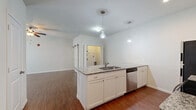 Located at 1305 S Heritage Pkwy in Sherman, Texas, this two-bedroom, one-bathroom residence offers a thoughtfully designed single-level layout. The open-concept kitchen serves as a central hub, anchored by a peninsula island with granite countertops, an undermount sink, and pendant lighting overhead. White shaker cabinetry, subway tile backsplash, and a full suite of stainless steel appliances — including a refrigerator, electric range, built-in microwave, and dishwasher — complete the kitchen's polished, functional aesthetic. Rich hardwood-style flooring flows throughout the main living areas and kitchen, adding warmth and continuity. The primary bedroom features a ceiling fan, a stylish sliding barn door leading to the bathroom, and access to a dedicated closet. The second bedroom is carpeted and includes its own ceiling fan and a walk-in closet with wire shelving for ample storage. The bathroom is cleanly finished with a granite-topped vanity, white cabinetry, and a full tub-shower combo. A dedicated laundry room with washer and dryer hookups provides added convenience. Throughout the home, neutral tones and clean lines create a bright, welcoming atmosphere.