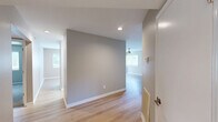 Located at 130 W Crescent Square Dr, this single-floor home offers a practical and comfortable layout across three bedrooms and three full bathrooms. The living room serves as the heart of the home, featuring light wood laminate flooring, a modern ceiling fan, and large sliding glass doors flanked by windows that flood the space with natural light and provide views of the surrounding greenery outdoors. A pass-through window connects the living area to the kitchen, which is equipped with stainless steel appliances, including a full-size refrigerator and electric range, set against white cabinetry and a clean countertop. The bedrooms are carpeted in neutral tones and receive natural light through windows with blinds. The primary bedroom offers a comfortable footprint with easy access to the hallway. Bathrooms are clean and functional, featuring full tub-shower combinations with chrome fixtures. Light wood flooring extends through the hallways, adding warmth and continuity throughout. A dedicated utility room provides additional practical storage. The overall aesthetic is clean and neutral, with soft taupe and gray tones throughout, creating a bright and inviting atmosphere well-suited for everyday living.