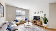 Located at 5300 Oak Passage Dr in Columbus, OH, this thoughtfully designed single-floor residence offers 1 bedroom, 2 bathrooms, an office, and a seamless open-concept layout. The bright living room features light hardwood-style flooring, large windows that invite abundant natural light, and easy access to the kitchen area. The kitchen is a standout, boasting crisp white shaker cabinets, dark granite countertops, a subway tile backsplash, stainless steel appliances, and a spacious island with pendant lighting and bar seating — ideal for both cooking and entertaining. The generous primary bedroom is carpeted for comfort, bathed in natural light from a large window, and offers ample space for a full furniture arrangement. Two well-sized closets provide excellent storage throughout. Both bathrooms are finished with white vanity cabinetry, dark countertops, and light wood-style flooring, with a bright vanity mirror and modern lighting. A dedicated office space adds versatility to the floor plan. The neutral, warm color palette and consistent modern finishes create a cohesive and inviting ambiance throughout this well-planned Columbus residence.