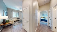 Located at 920 W Combs Rd in Queen Creek, Arizona, this single-story residence offers a thoughtfully designed layout with modern finishes throughout. The interior features durable wood-look plank flooring that flows seamlessly across all areas, complemented by neutral warm-toned walls that create a bright, welcoming atmosphere.

The kitchen is a standout feature, equipped with crisp white shaker cabinetry, light quartz countertops, stainless steel appliances including a range, microwave, and dishwasher, and a central island with bar seating — ideal for casual dining and entertaining. An adjacent dining nook benefits from generous natural light through large windows with horizontal blinds.

The living room offers a comfortable, open feel with multiple windows, a ceiling fan, and direct access to an outdoor area via a glass door. The primary bedroom is well-proportioned, featuring a ceiling fan and natural light, while a secondary bedroom provides additional flexible living space.

A dedicated mudroom off one of the hallways includes built-in shelving, hanging hooks, and a bench — a practical organizational space. Bathrooms are finished with white vanities and wood-look flooring, maintaining a consistent and clean aesthetic. The single-floor layout ensures easy accessibility and efficient flow throughout this well-designed Queen Creek home.