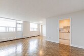 Located at 1257 Lakeshore Rd E in Mississauga, this well-laid-out 2-bedroom, 1-bathroom unit offers a practical and comfortable single-floor living arrangement. The space is defined throughout by warm parquet wood flooring in a classic basket-weave pattern, lending character and continuity across the living room, bedrooms, and hallway.

The living room is an open, airy space highlighted by large windows that bring in generous natural light and offer elevated views of the surrounding neighbourhood. Baseboard heating runs along the perimeter, ensuring warmth throughout the seasons. The kitchen is efficiently designed with modern stainless steel appliances, including an electric range with an over-the-range microwave, and features tile flooring and white cabinetry. It connects directly to the living area through an open pass-through for easy flow.

The spacious primary bedroom includes a closet and benefits from corner windows framing outdoor views. The second bedroom is well-sized with its own closet and parquet flooring. The bathroom is clean and updated, featuring a tiled shower-tub combination with white subway tiles accented by a grey ceramic border strip and chrome fixtures. A hallway with additional closet space completes the layout, providing practical storage throughout.