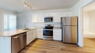 This single-floor residence at 1 Ari Drive in Westbrook, Maine offers a clean, contemporary design throughout. The open-concept living and dining area is finished with light wood-style flooring, crisp white walls, and large windows that invite abundant natural light and views of the surrounding neighborhood. A wall-mounted mini-split unit provides efficient climate control, complemented by baseboard heating found throughout the unit.

The kitchen is thoughtfully equipped with white shaker-style cabinetry, granite-look countertops, a stainless steel sink, and a full suite of stainless steel appliances, including a refrigerator, range, microwave, and dishwasher. Track lighting above the kitchen adds both functionality and a modern touch.

The bedrooms feature soft carpeting, neutral tones, and ceiling fans, with one room offering a walk-in closet. Each bedroom benefits from natural light through well-placed windows with outdoor views of greenery.

The bathroom is finished with wood-style flooring, a white vanity with chrome fixtures, a large mirror, and a full tub-shower combination. Clean lines and neutral finishes carry a consistent, modern aesthetic across the entire space.