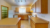 Located at 1770 Dublin Trail in Neenah, Wisconsin, this single-floor unit offers a practical and well-organized layout designed for comfortable everyday living. The kitchen is a functional centerpiece, featuring warm wood-tone cabinetry, ample counter space, a central island, tile flooring, and white appliances including a range, dishwasher, and refrigerator. Track lighting illuminates the space, and a window above the sink brings in natural light with views of the surrounding greenery.

The bedrooms are carpeted and finished with neutral tones, warm wood baseboard trim, and ceiling fans for year-round comfort. Each room includes baseboard heating and windows that allow natural light in while offering outdoor views. Closet space is accessible directly from the bedroom areas, providing convenient storage.

A dedicated laundry area accommodates a full-size washer and dryer, adding in-unit convenience. Additional built-in shelving provides organized storage nearby. The bathroom includes a full tub-shower combination with tile flooring and clean, neutral finishes throughout.

The overall layout, visible in the floorplan view, is open and efficiently organized, connecting the kitchen, living areas, and private rooms in a cohesive flow. Vaulted ceilings in select areas add a sense of openness to the space.