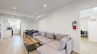 Located at 1297 1/4 W 36th St in Los Angeles, CA, this single-story unit offers a clean, modern aesthetic defined by crisp white walls, light wood-style flooring, and recessed lighting throughout. The open living and dining area serves as the heart of the space, providing a welcoming gathering area with generous natural light and direct access to the exterior via a glass-paneled entry door. The kitchen is well-appointed with white shaker cabinetry, white quartz countertops, a subway tile backsplash, stainless steel appliances including a gas range, dishwasher, and refrigerator, plus a window that brings in additional natural light. Multiple bedrooms offer comfortable accommodations, each featuring windows with exterior views, light wood-style flooring, and ample closet storage. The bathrooms maintain the home's clean design language with white tiled walk-in showers, modern vanities, and chrome fixtures. An in-unit stacked washer and dryer adds everyday convenience. Throughout the space, a consistent palette of white walls and light flooring creates a bright, cohesive atmosphere that feels fresh and move-in ready.